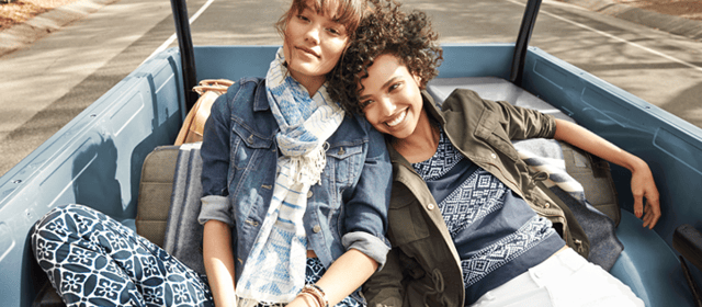 two women on a road trip in the back of a car on the road