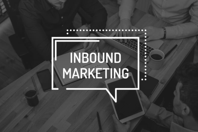 inbound marketing message over desk with marketers on tablet, laptop, and notebook