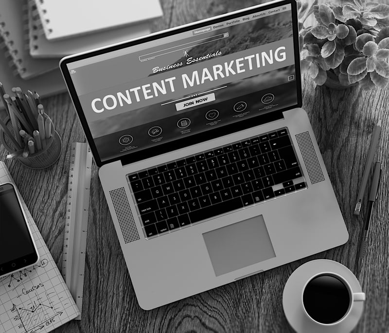 laptop screen on desk displays content marketing essential strategy