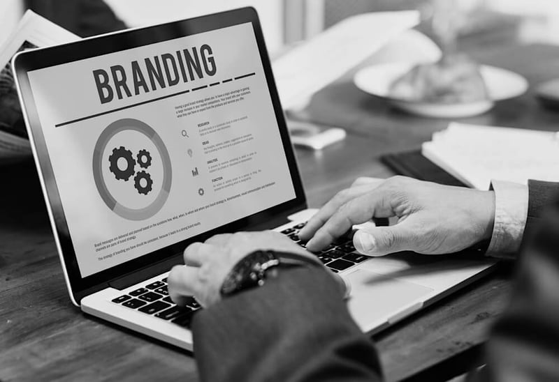 businessman hands on laptop at desk working on branding development and strategy