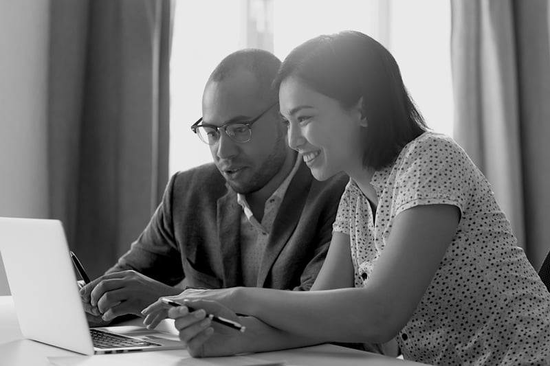 Asian-American woman and African-American man in front of laptop on desk