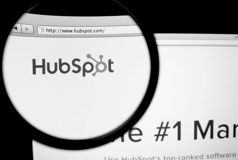 magnifying glass over a website screen for HubSpot.com