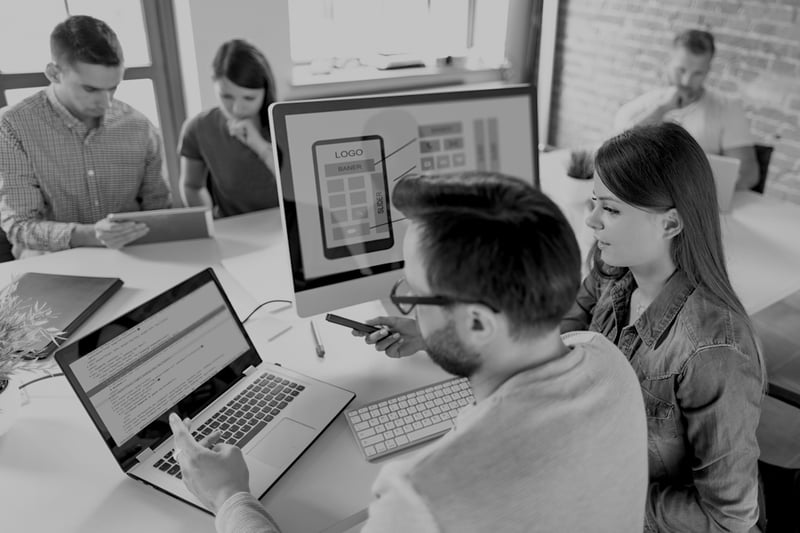 male and female marketers analyzing website design on laptop screens