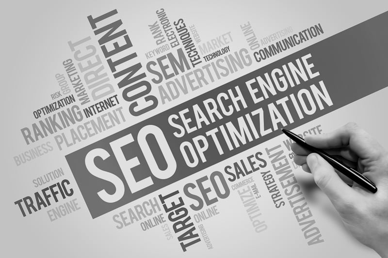 hand with pen writing about SEO search engine optimization