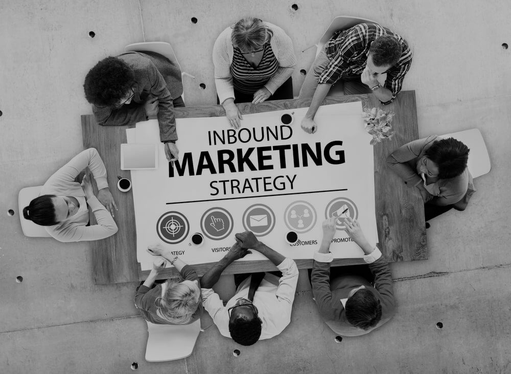 overhead view of group of marketers sitting around a table with inbound marketing strategy in the middle